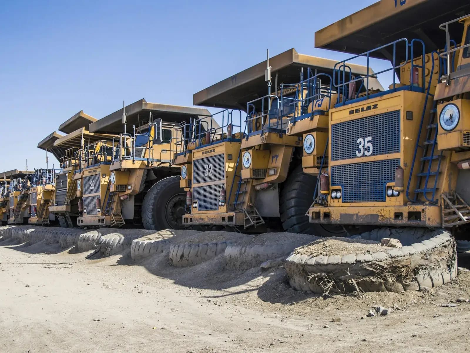 A contracting company's ute parked alongside an excavator on an Australian mine site