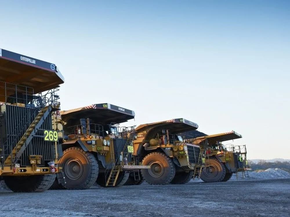 A line of haul trucks parked at an Australian mine site